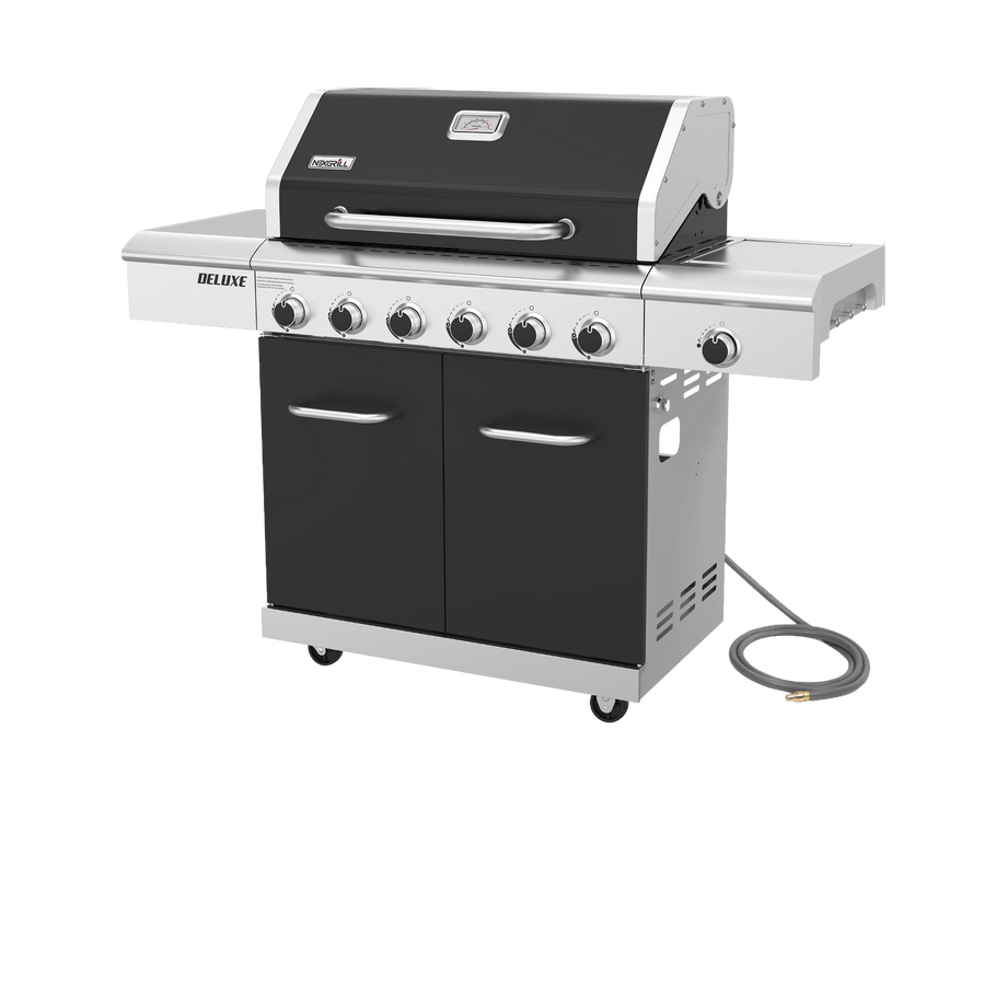 A Nexgrill Deluxe 6-Burner Natural Gas Grill in black, featuring a silver finish, six control knobs, side shelves, storage cabinets, and a gas hose on the right side. This grill includes the Gourmet Plus Cooking System and a ceramic searing side burner, and is photographed against a plain white background.
