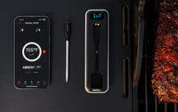 Nexgrill smart wireless meat probe thermometer device with smartphone showing Nexgrill app on a black background